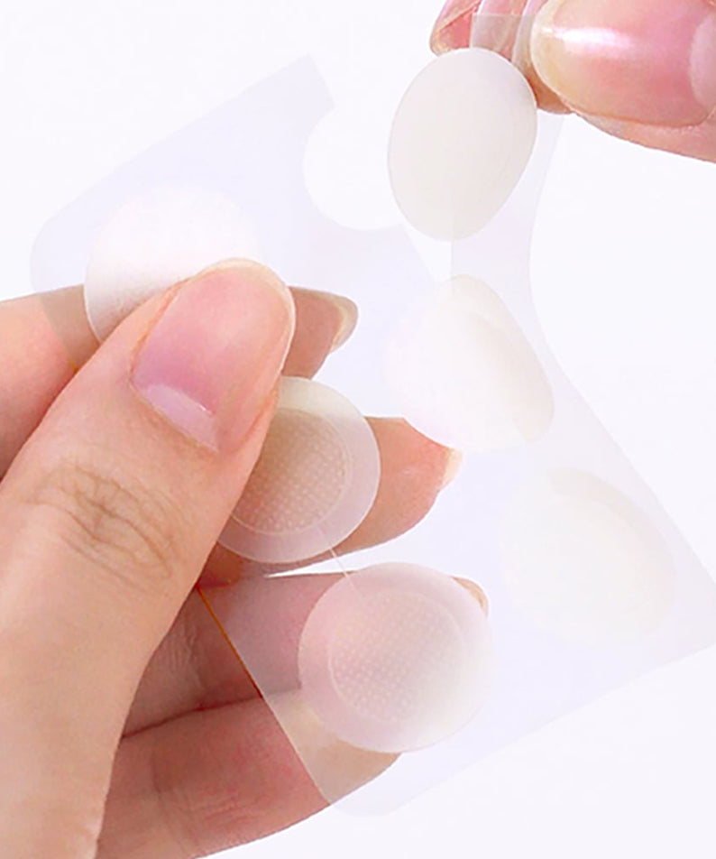 Person holding THE SAEM Golden Berry C Dark Spot Patch with transparent circular patches in hand.