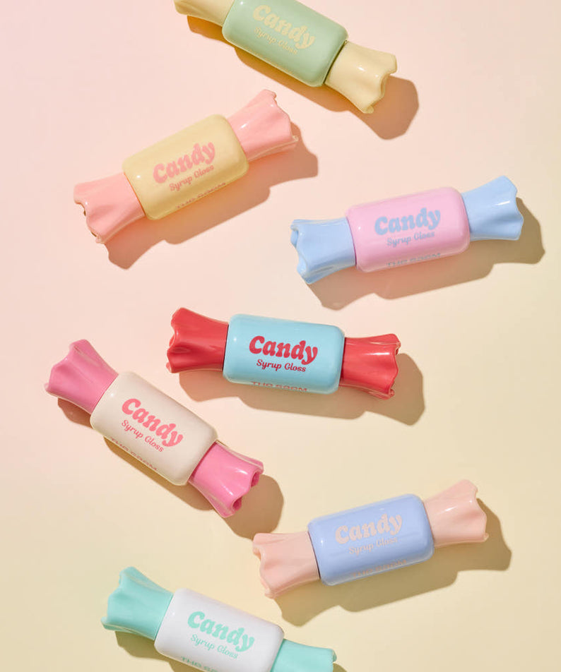 Colorful tubes of THE SAEM Saemmul Candy Syrup Gloss styled as candies, showcasing vibrant packaging on a pastel background.
