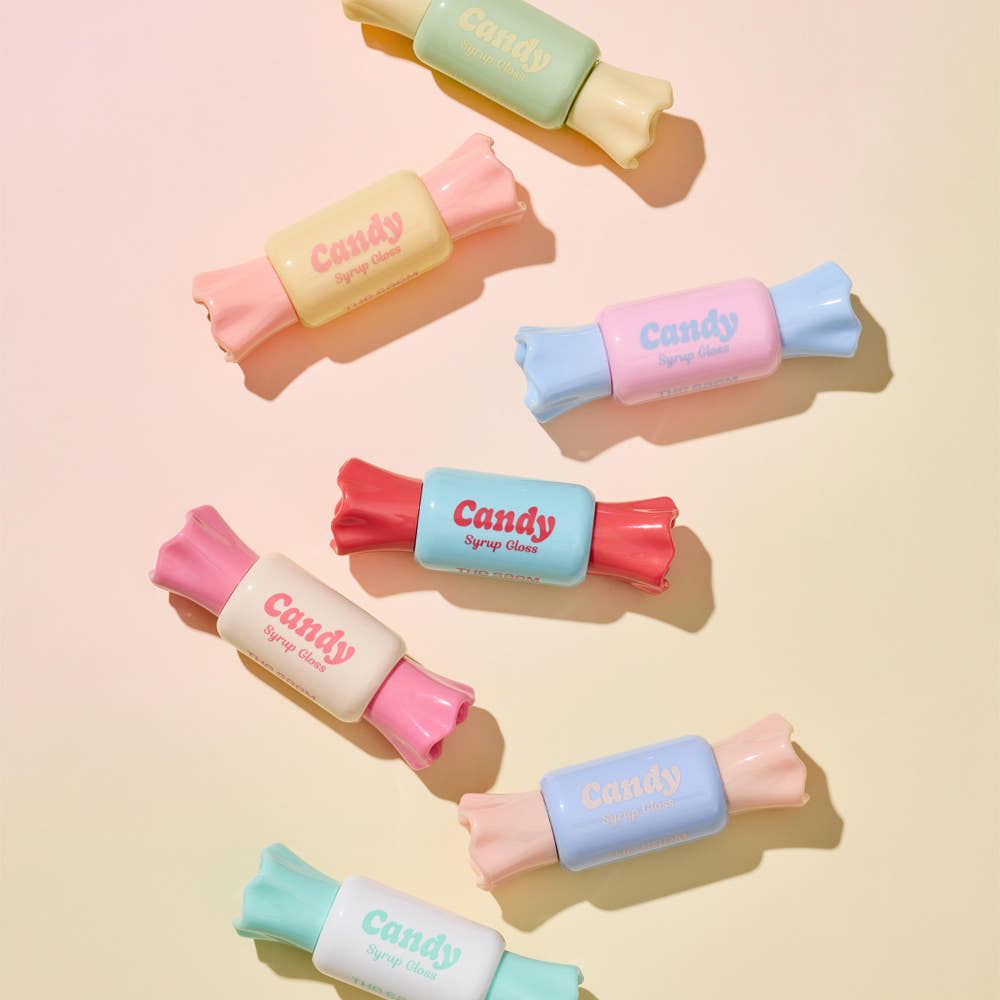 Colorful tubes of THE SAEM Saemmul Candy Syrup Gloss styled as candies, showcasing vibrant packaging on a pastel background.