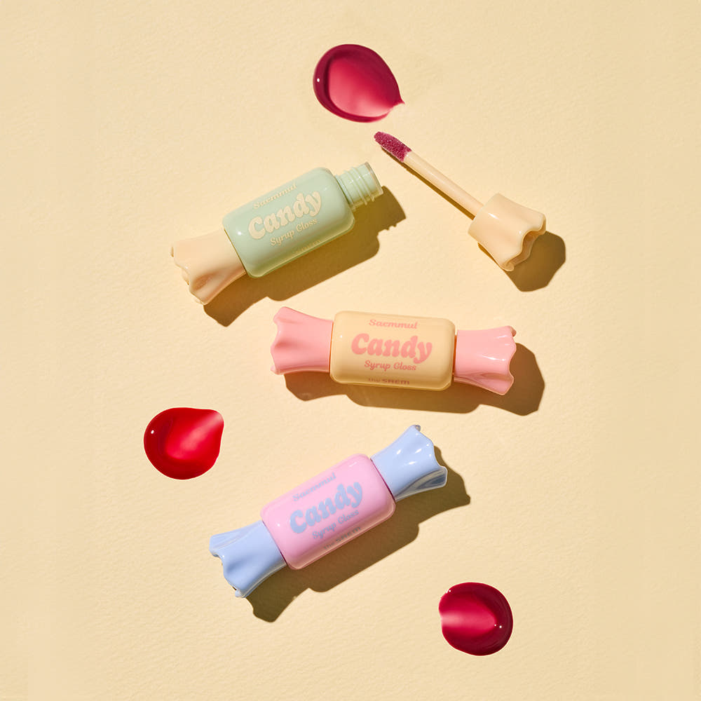 THE SAEM Saemmul Candy Syrup Gloss packaging with open gloss tube and colorful candy-shaped containers on beige background.