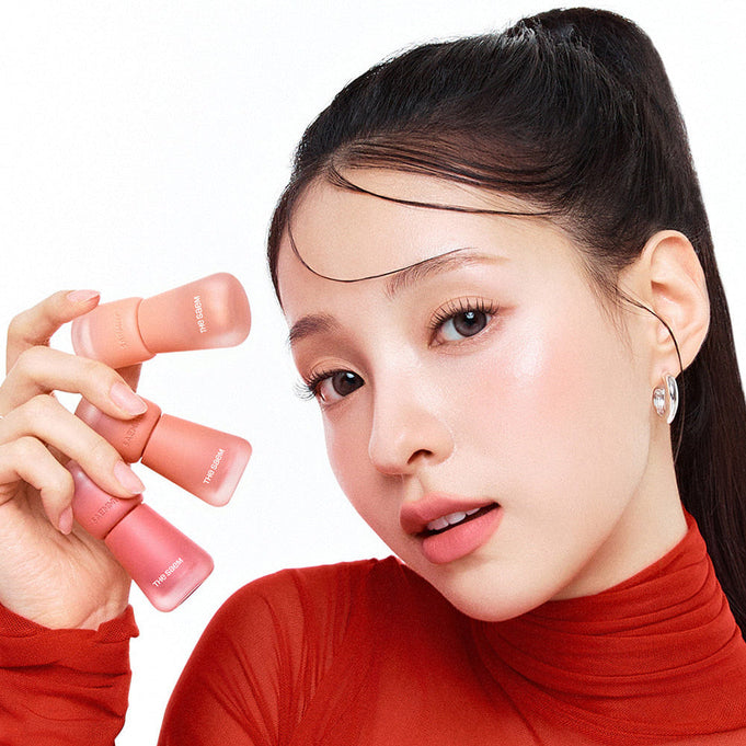 Model holding THE SAEM Saemmy's Crema Velvet Tint showcasing soft matte lip tint colors.