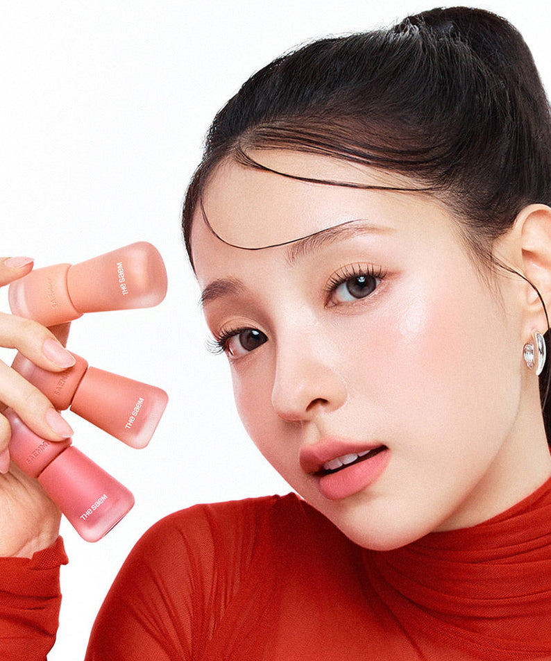 Model holding THE SAEM Saemmy's Crema Velvet Tint showcasing soft matte lip tint colors.