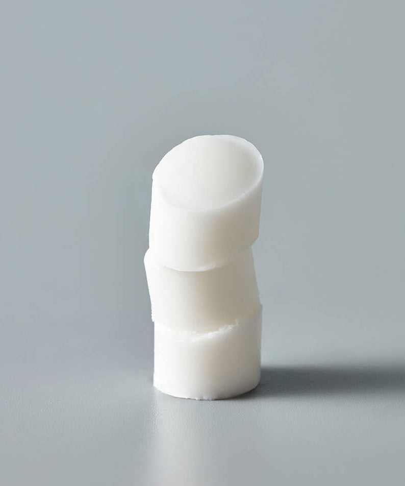 THE SAEM Soft Blurring Primer Lip Balm displayed on a grey background, emphasizing its smooth texture and creamy consistency.