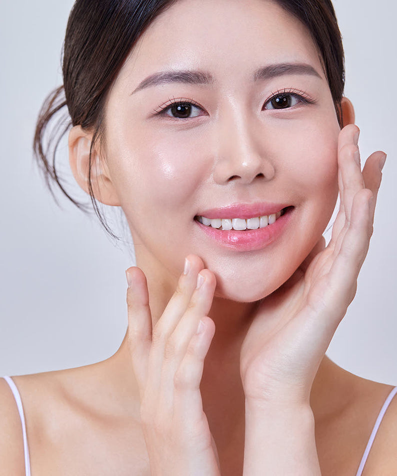 Smiling woman with clear skin, applying THE SAEM Temptation Age Return Eye Cream 30ml