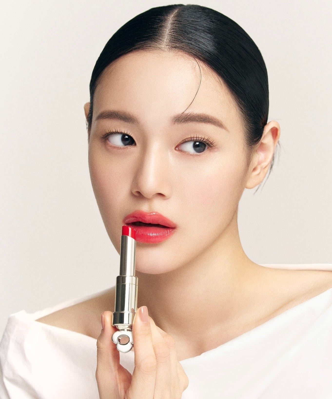 Model applying THE WHOO Essentail Lip Glow Balm for a vibrant lip color look.