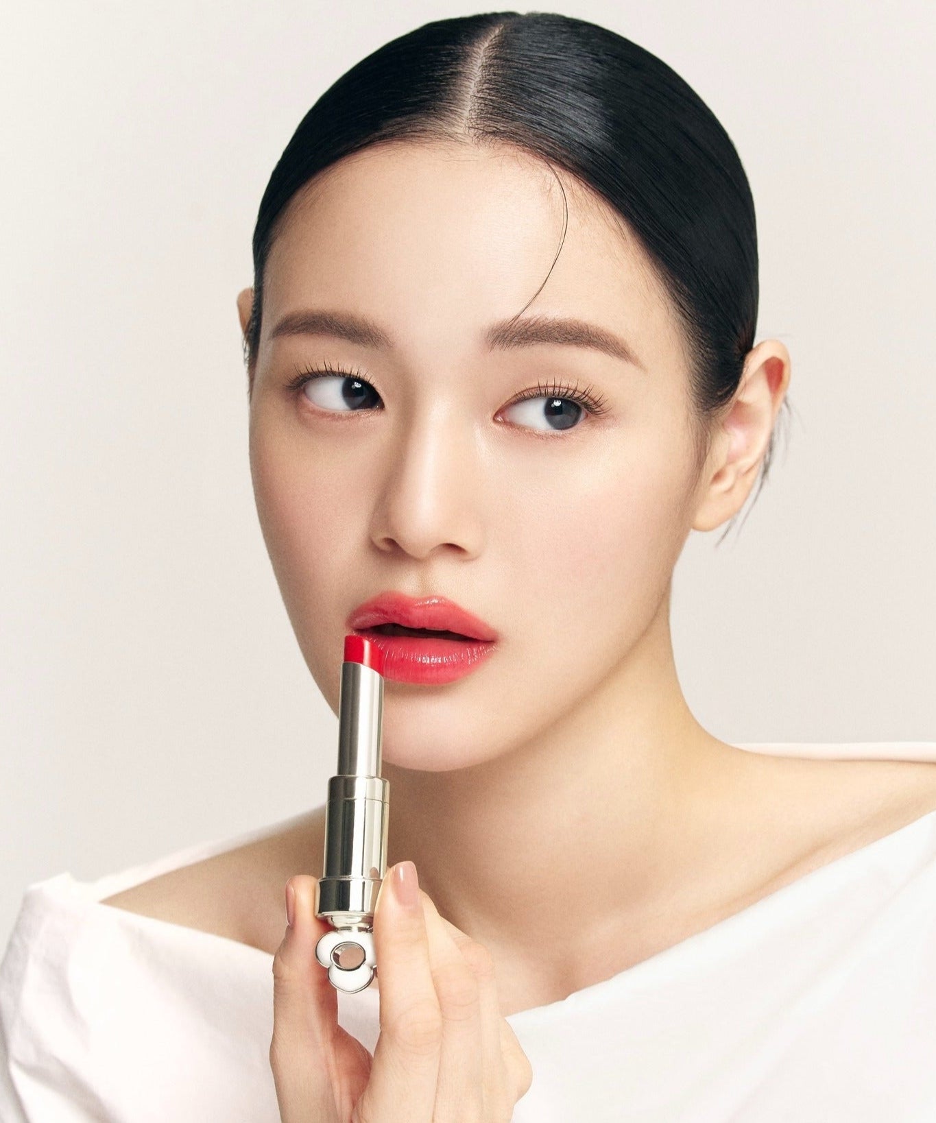 Model applying THE WHOO Essentail Lip Glow Balm for a vibrant lip color look.