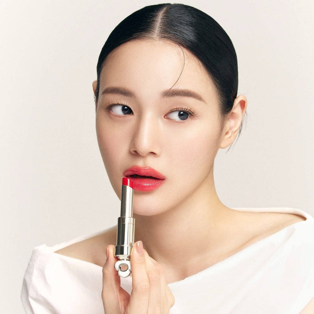 Model applying THE WHOO Essentail Lip Glow Balm for a vibrant lip color look.