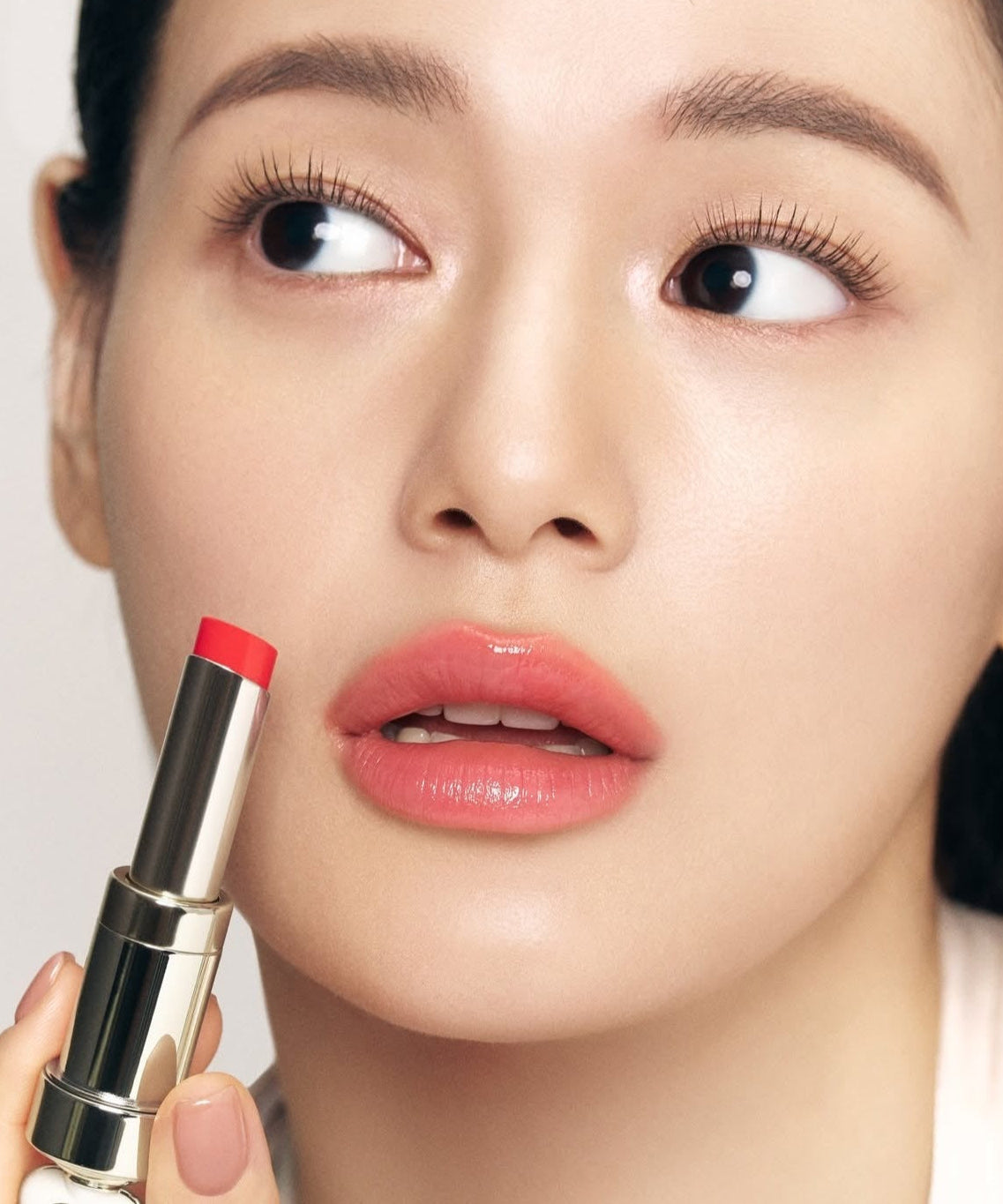 THE WHOO Essentail Lip Glow Balm applied by a model, showcasing vibrant lip shade for a natural look.