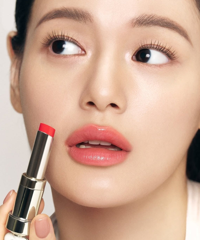 THE WHOO Essentail Lip Glow Balm applied by a model, showcasing vibrant lip shade for a natural look.