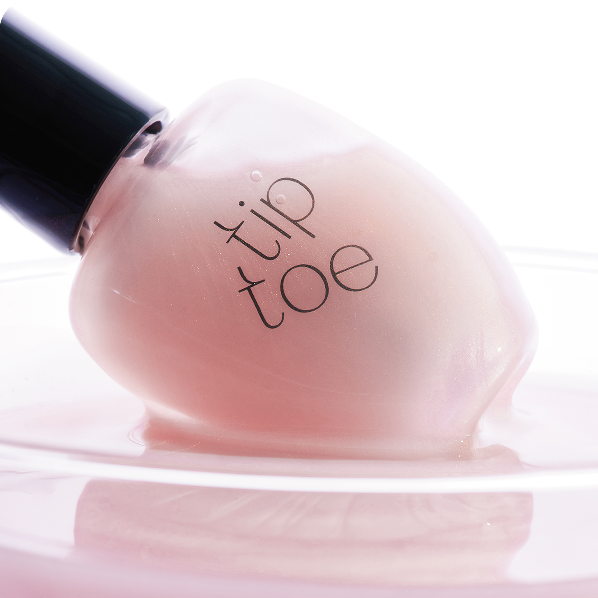 TIP TOE Sheer Topcoat Nail Polish bottle close-up on a light background.