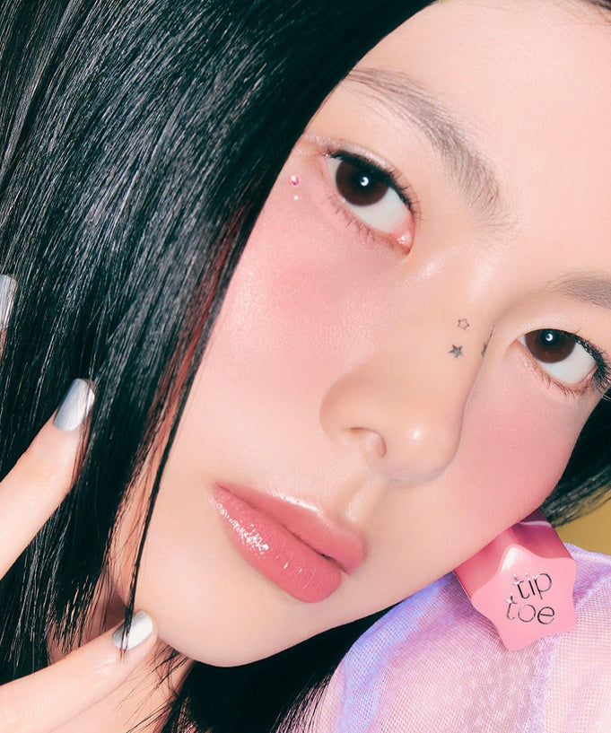 Model wearing TIP TOE Glowit Sorbet Tint showcasing a dewy finish and vibrant color on lips and cheeks.