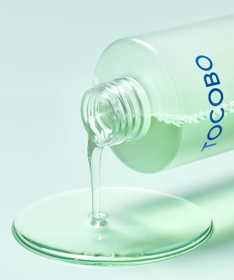 TOCOBO Cica Calming Aqua Toner pouring from bottle onto flat surface.