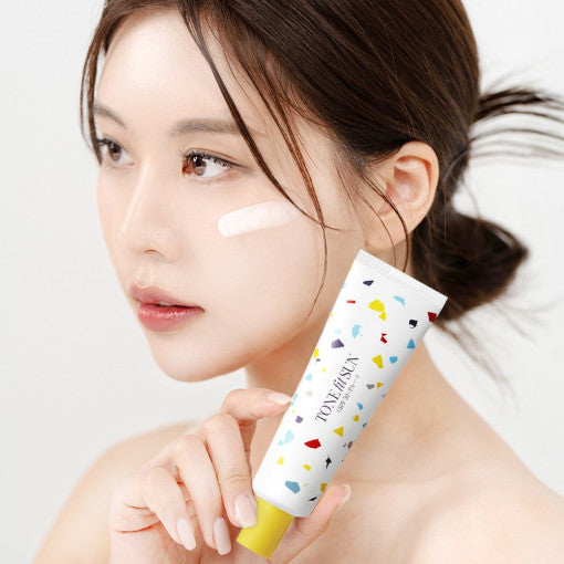 Woman applying TONE FIT SUN Vegan Hydro Sun Cream 50ml SPF50+ PA++++ to her face.