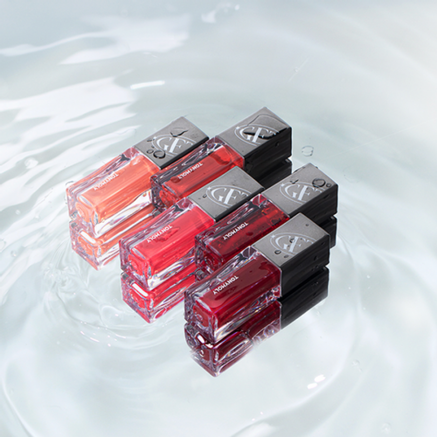 Group of TONY MOLY Get It Tint Colorful Water lip tints floating on water surface, featuring vibrant shades and glossy packages.