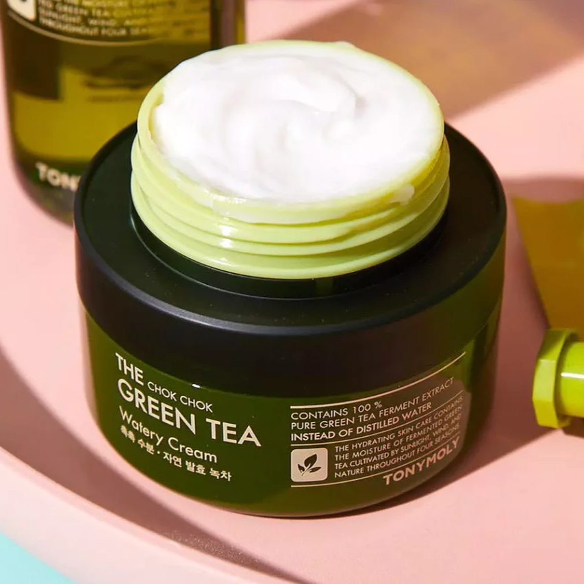 TONYMOLY More Moist Green Tea Gel Cream 60ml in an open jar on a pink surface with a green background.