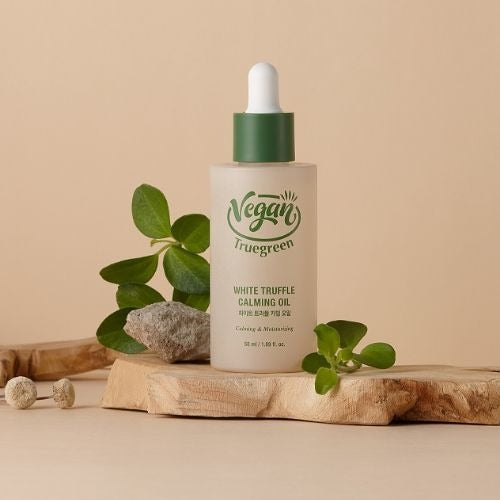 TONYMOLY Trugreen White Truffle Calming Oil 50ml bottle with natural accents, promoting a vegan product line on a wooden and plant backdrop.