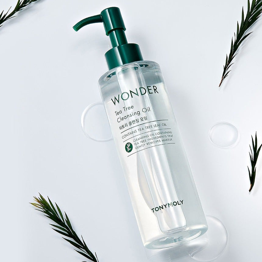 TONYMOLY Wonder Tea Tree Cleansing Oil 200ml bottle with green pump, surrounded by tea leaves on white background.