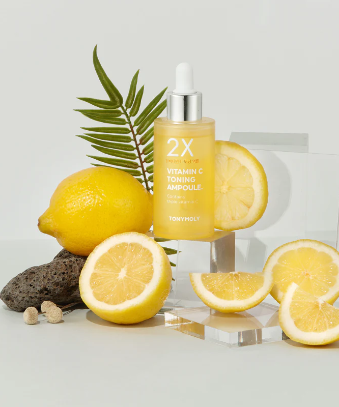 TONYMOLY 2X Vitamin C Toning Ampoule 50ml with fresh lemon slices displayed on a clear surface for vibrant skincare enhancement.