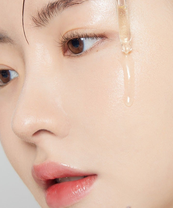 Close-up of person applying TONYMOLY 2X Vitamin C Toning Ampoule 50ml to skin, highlighting its brightening effect.
