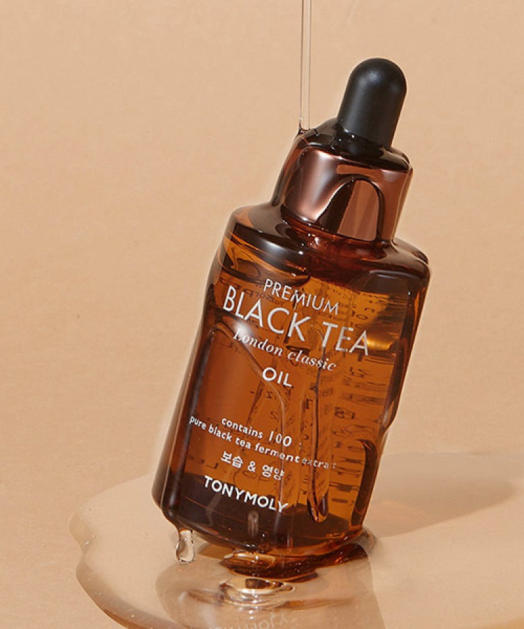 TONYMOLY Premium Black Tea London Classic Oil 35ml bottle with dropper and text visible on a beige background.