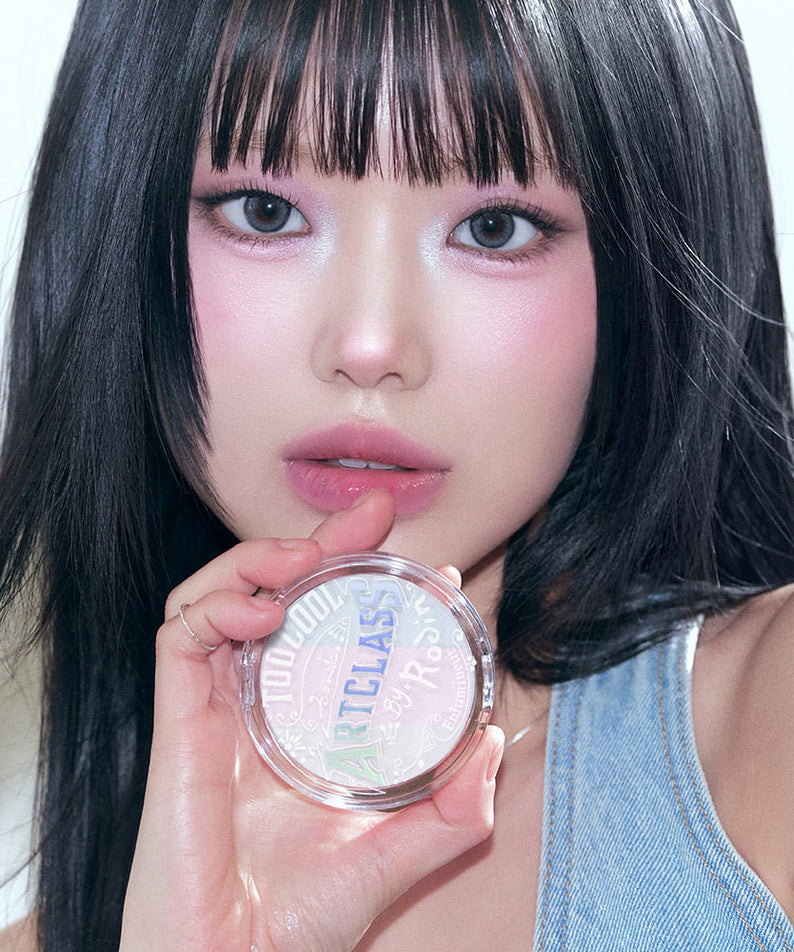 Model holding TOO COOL FOR SCHOOL Art Class By Rodin Highlighter in hand, showcasing makeup color and design.