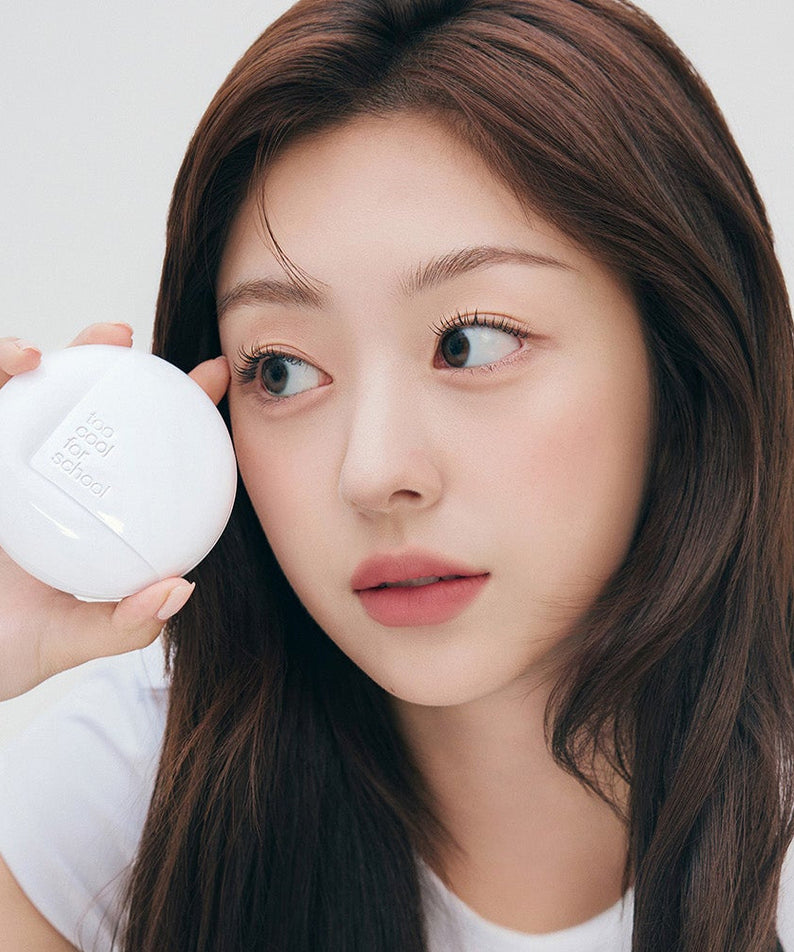 Woman holding TOO COOL FOR SCHOOL Fixing Cover Fit Cushion [Product + Refill] near her face