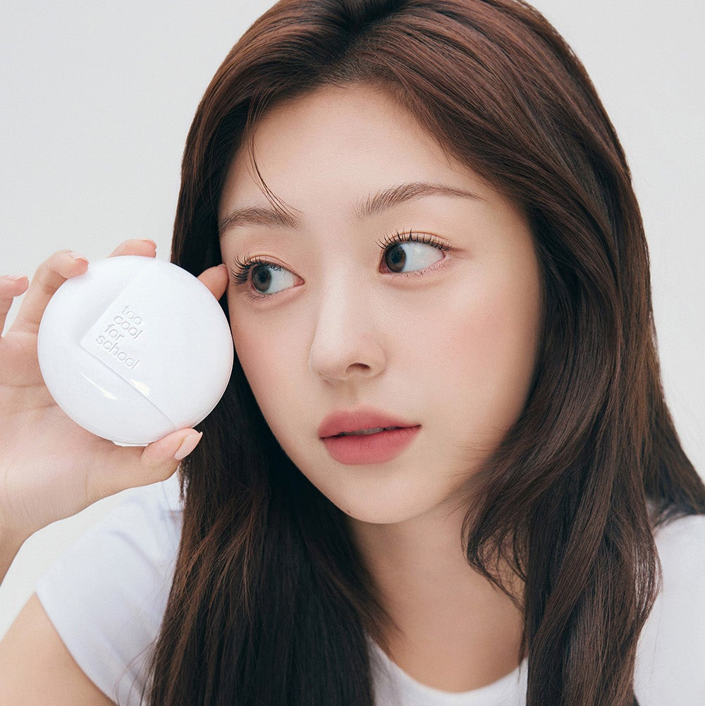 Woman holding TOO COOL FOR SCHOOL Fixing Cover Fit Cushion [Product + Refill] near her face