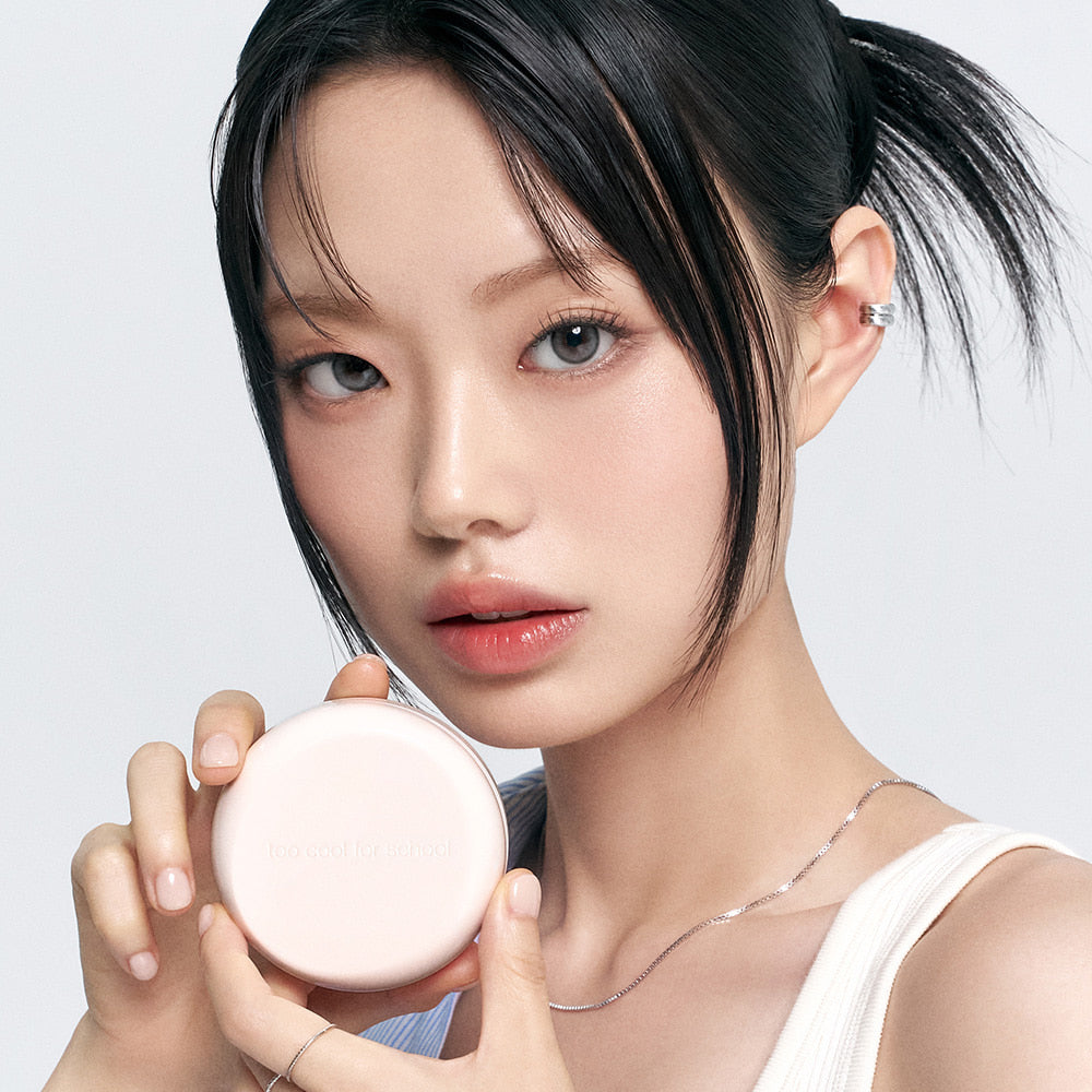 Model holding TOO COOL FOR SCHOOL Fixing Dew Cushion [Main Product + Refill], showcasing beauty product packaging.