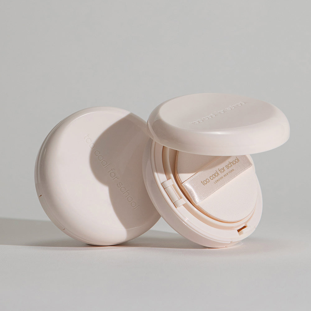 TOO COOL FOR SCHOOL Fixing Dew Cushion [Main Product + Refill] compact open with neutral beige packaging on grey background.
