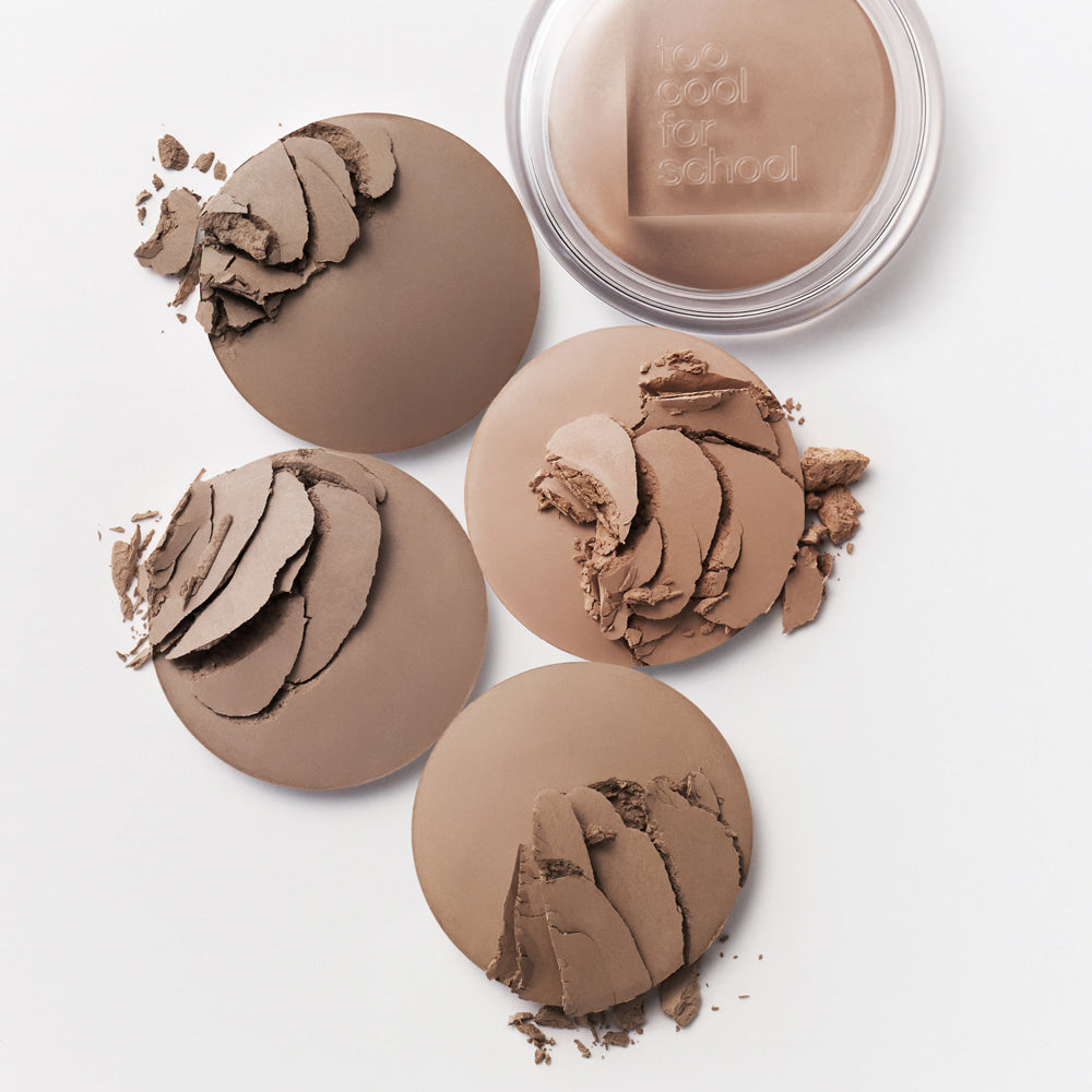 TOO COOL FOR SCHOOL Veiled Contour pressed powder makeup collection with four shades and open compact on white background.