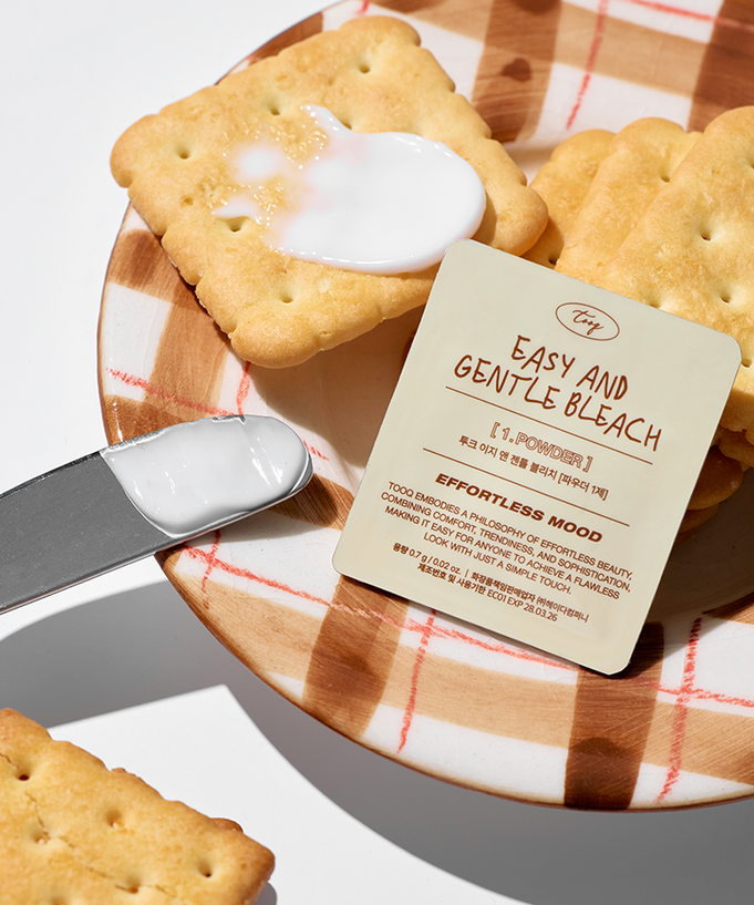 TOOQ Easy And Gentle Bleach packaging with a knife, crackers, and cream, marketing a gentle bleaching product by TOOQ.