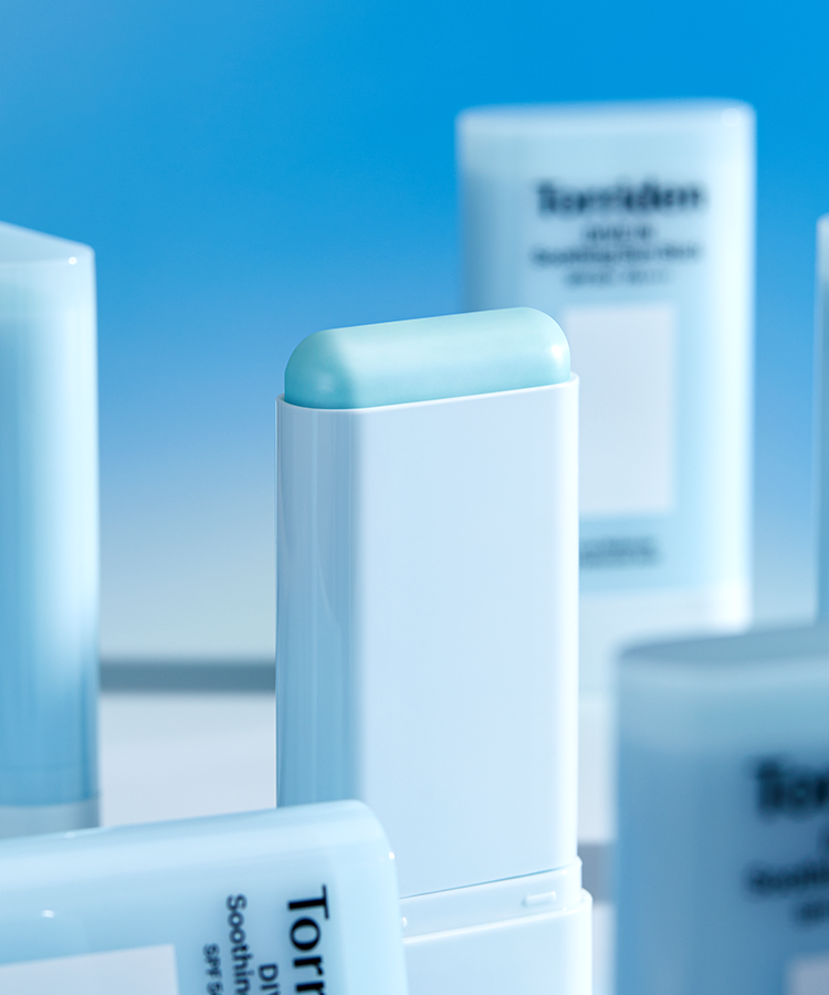 Close-up of TORRIDEN Dive In Soothing Sun Stick SPF50+PA++++ 19g with multiple sun sticks in the background.