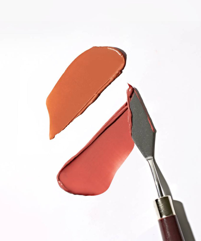 TOUCH IN SOL Vegan Again Juicy Plumping Lipstick swatches on white background with metal spatula.