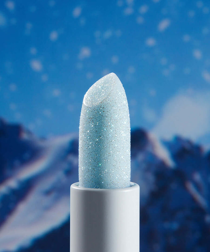UNLEASHIA Glacier Vegan Lip Balm against a snowy mountain backdrop