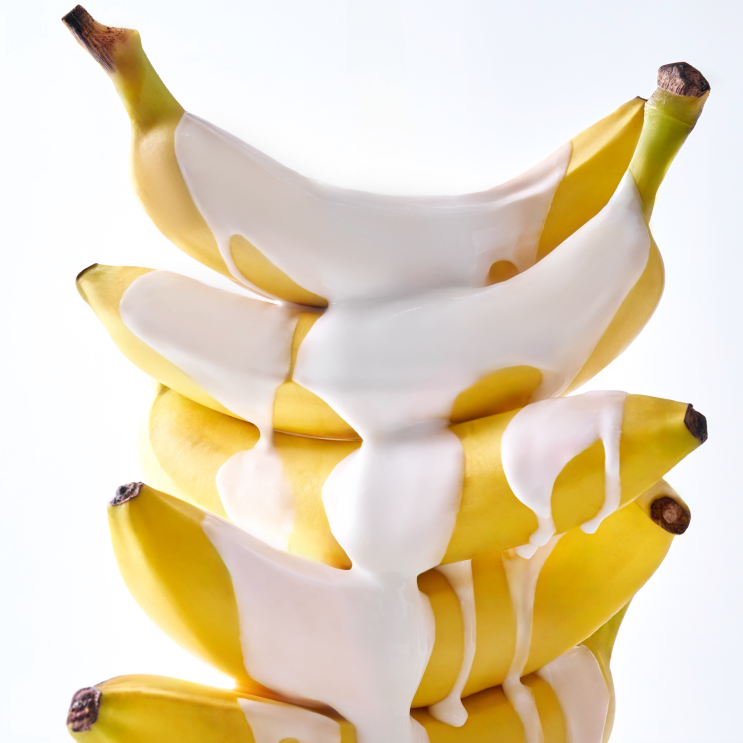 Fresh bananas covered in creamy lotion, concept related to UNLEASHIA Niacinamide Banana Sun Serum 40ml skincare product.