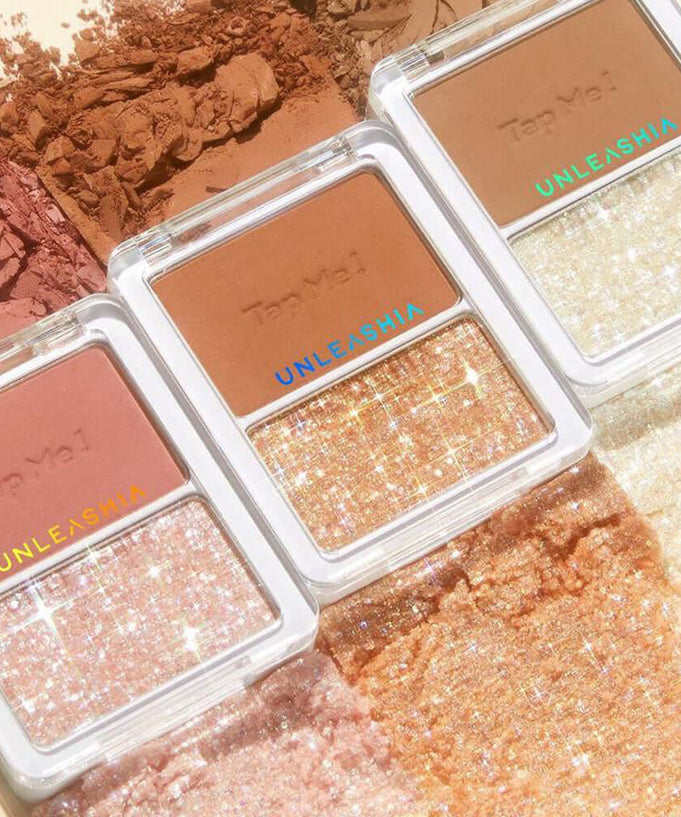Three UNLEASHIA tap me palette duo sets displaying a variety of shimmering and matte shades arranged on a textured background.