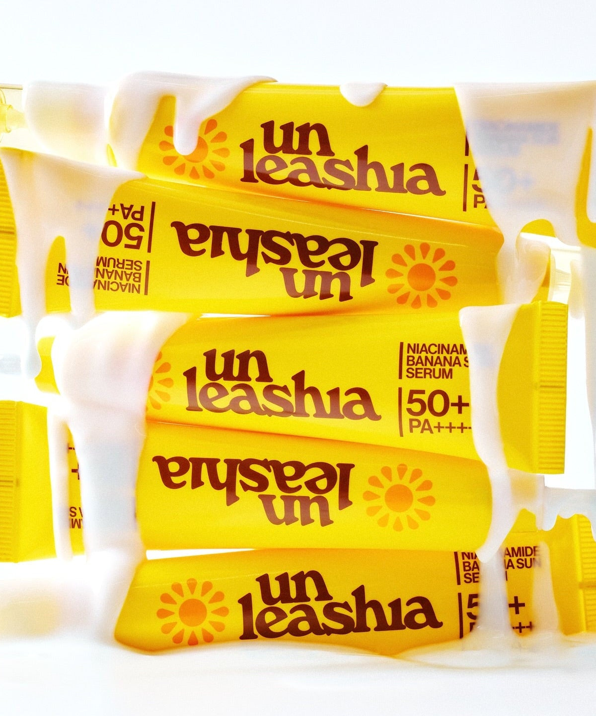 UNLEASHIA Niacinamide Banana Sun Serum 40ml tubes stacked with cream covering them.