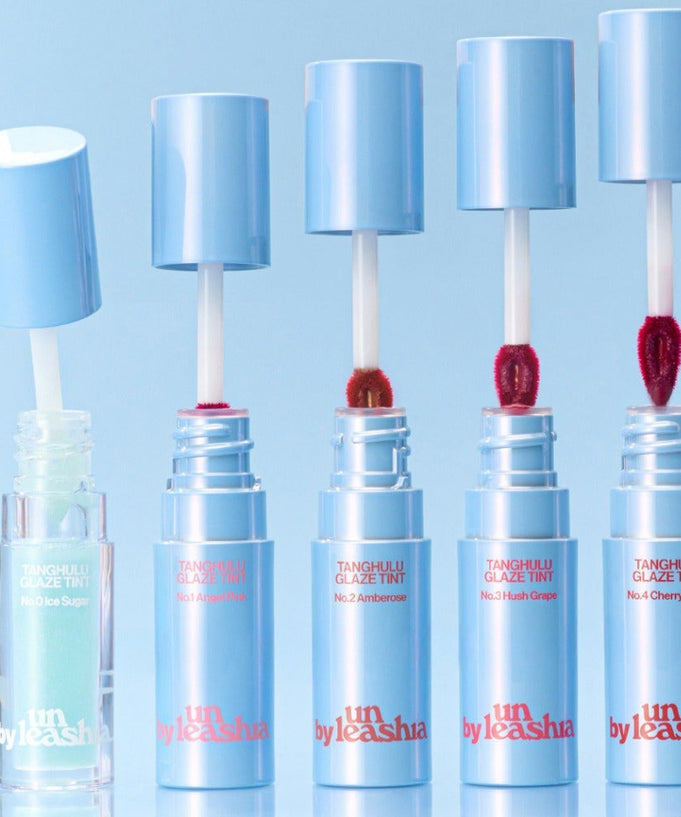 Five UNLEASHIA Tanghulu Glaze Tint tubes in different shades on a blue background.