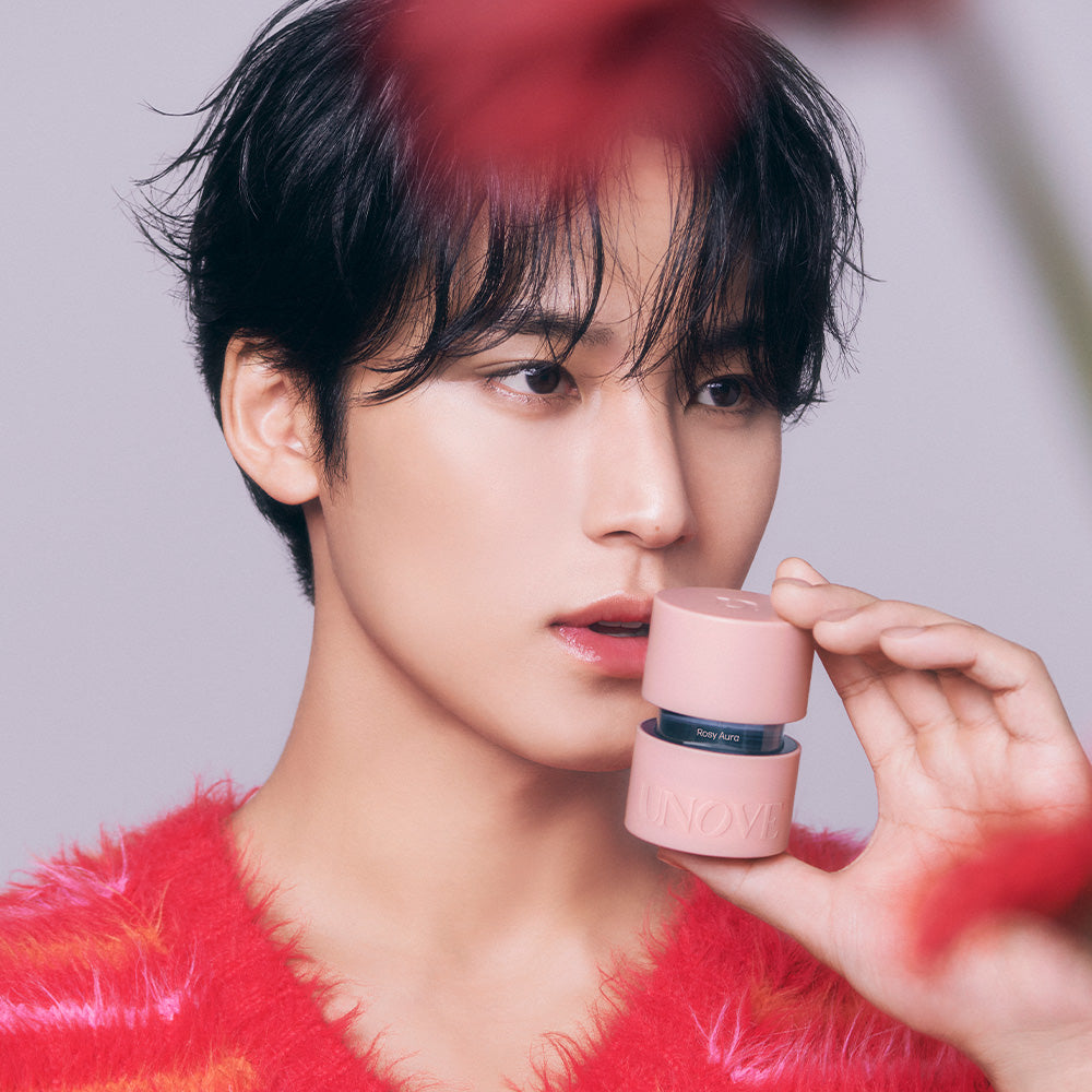 Person holding UNOVE Eau De Parfume bottle close to face