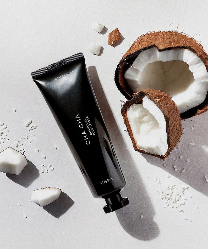 UNPA Cha Cha Charcoal Original Toothpaste 100g with coconut pieces on a white background.