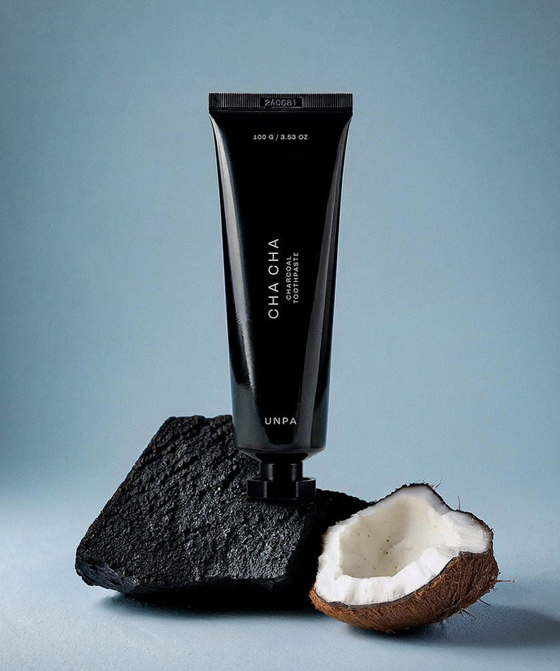 UNPA Cha Cha Charcoal Original Toothpaste 100g tube with charcoal and coconut on blue background