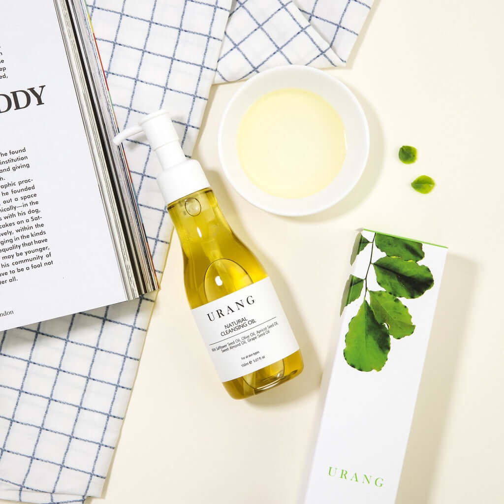 URANG Natural Cleansing Oil 150ml bottle with packaging and bowl, natural skincare product display on a cloth background.