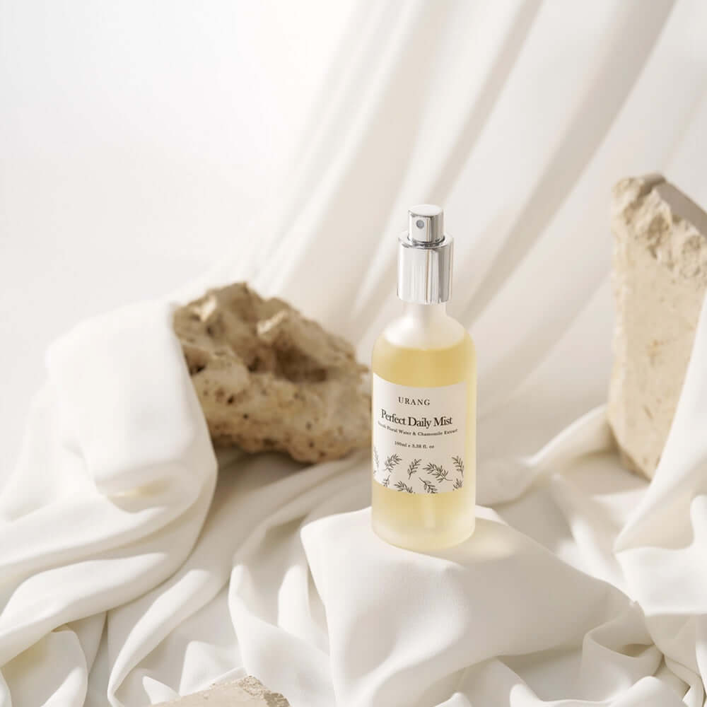 URANG Perfect Daily Mist 100ml bottle on white fabric with rocks in the background