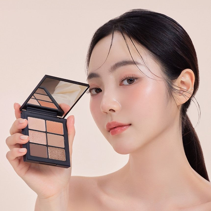 Person showcasing VIDIVICI Millennial Ambient Glow Eyes Palette with soft makeup look.