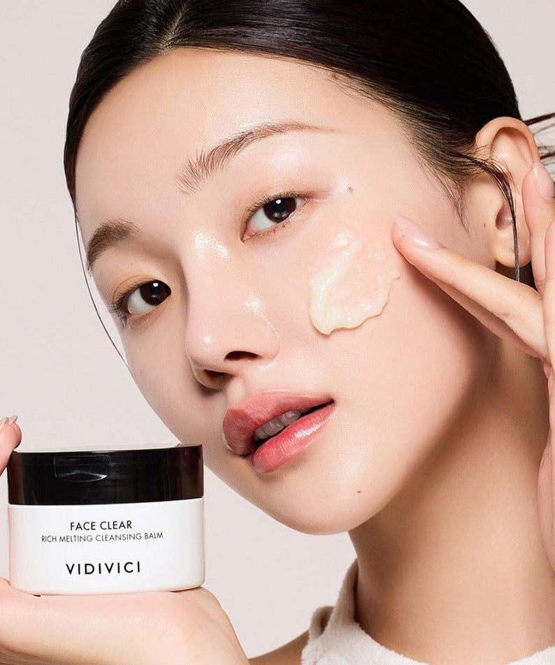 Model applying VIDIVICI Face Clear Rich Melting Cleansing Balm 100ml on her cheek, demonstrating skincare product effectiveness.