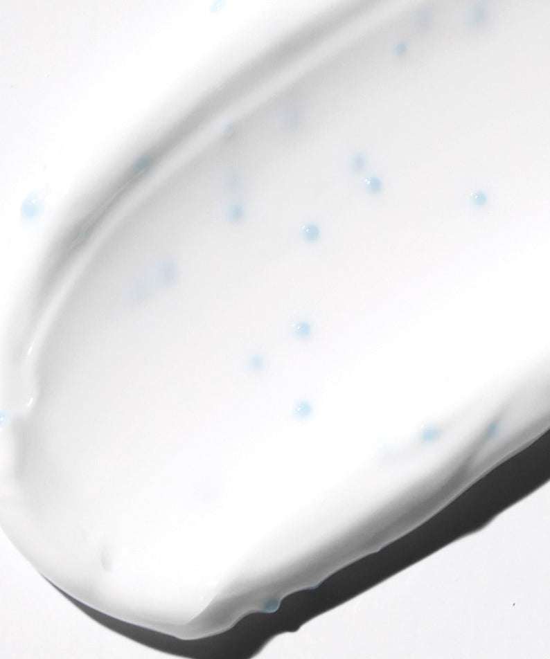 Texture of VT COSMETIC PDRN Cream RX 60ml showing moisturizing cream with blue microbeads on a white background.
