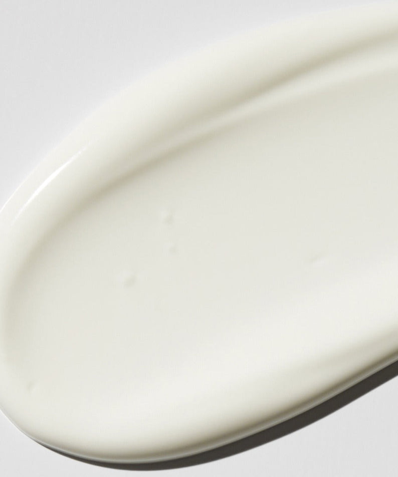 Close-up of VT COSMETIC PDRN Moist Tone-Up Sun Essence 50g's creamy texture on a smooth surface.
