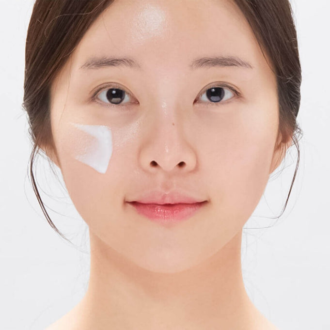 Woman applying VT COSMETIC PDRN Moist Tone-Up Sun Essence RX 60ml on face