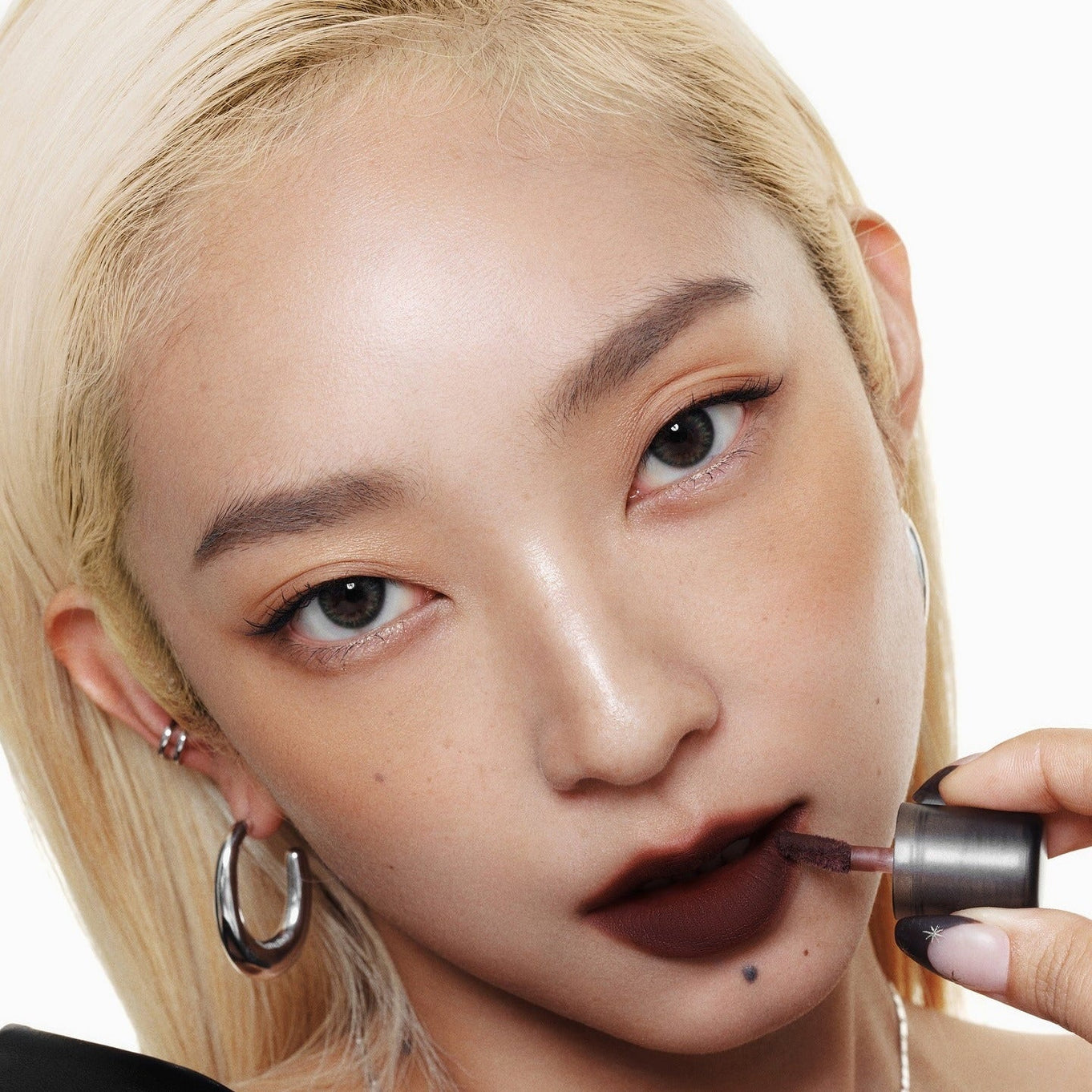 Model applying WAKEMAKE Soft Blurring Balm Stick for a soft, blurred lip effect.