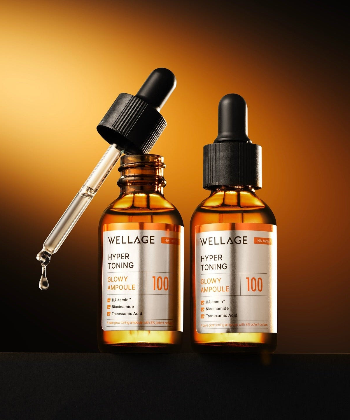 Two bottles of WELLAGE Hyper Toning Glow Ampoule 30ml with a dropper on a dark background.